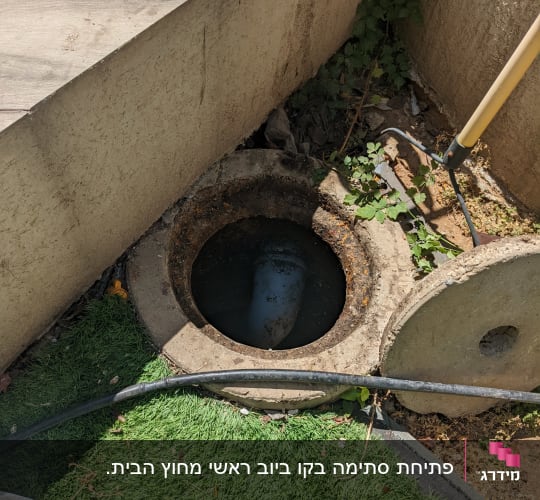 פתח ביוב עם צינור חשוף על דשא סינתטי